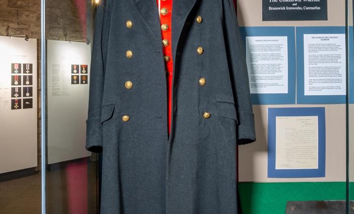 The RWF Greatcoat worn by King George V, alongside the prototype ironwork for the coffin of "The Unknown Soldier." Produced at Caernarfon by the Bruns